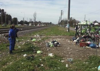 (Agente de Policía local junto a Julio Sosa, el vecino que realizó la denuncia- A la derecha el contenedor debajo del cual se encontró a la niña)