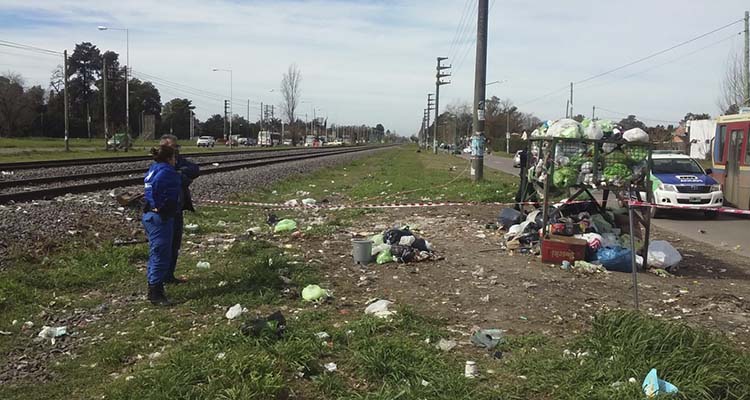 (Agente de Policía local junto a Julio Sosa, el vecino que realizó la denuncia- A la derecha el contenedor debajo del cual se encontró a la niña)